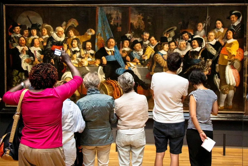 "A group of people viewing an art exhibit, demonstrating the importance of community amenities and social activities in senior-friendly housing options."