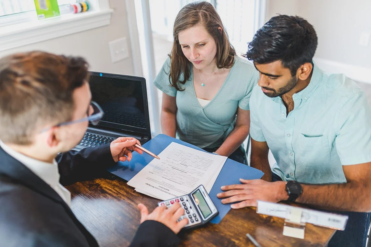 Real estate agent reviewing documents with a young couple